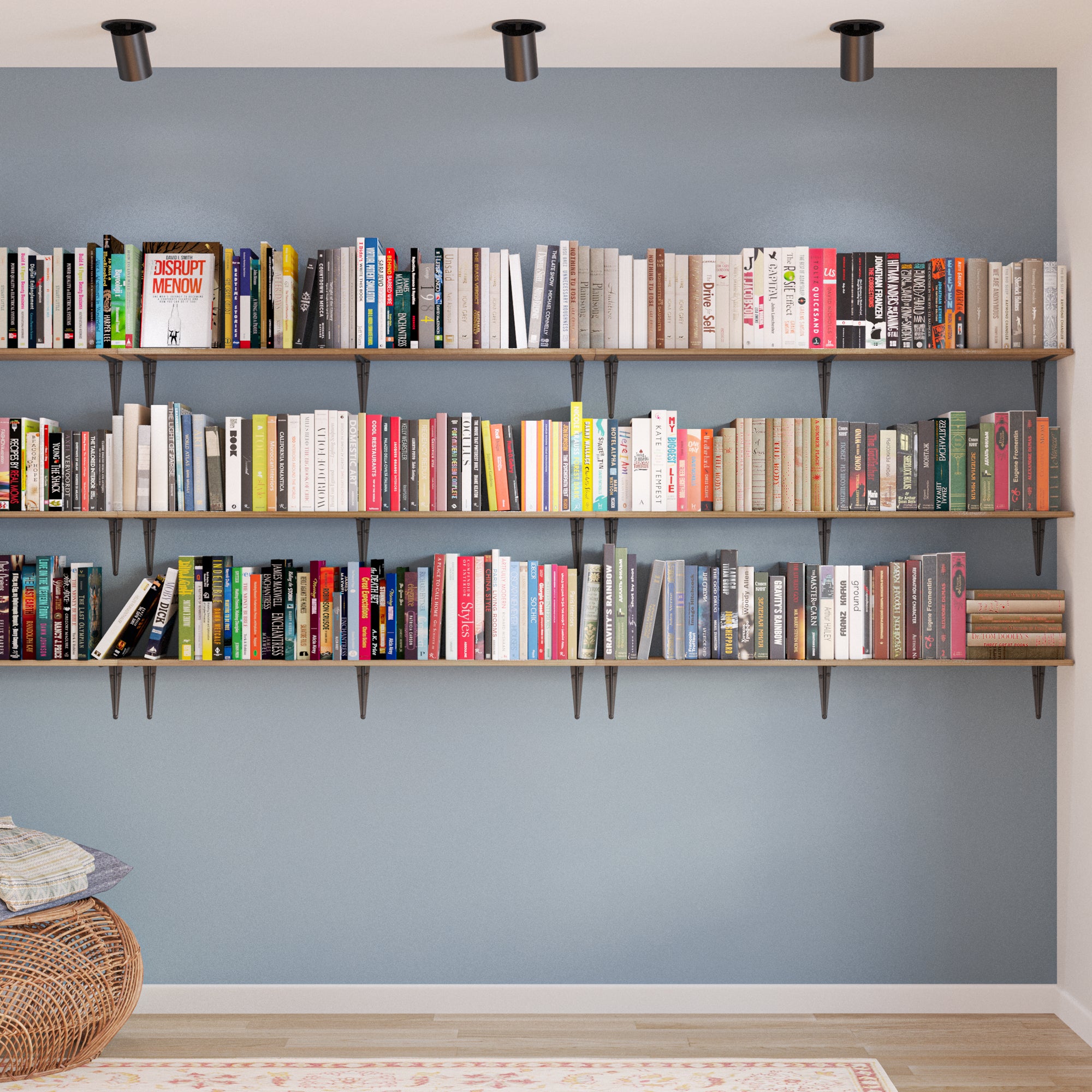 Multi-tiered wall-mounted bookshelves filled with a colorful and extensive book collection, creating a home library feel against a soft blue accent wall.
