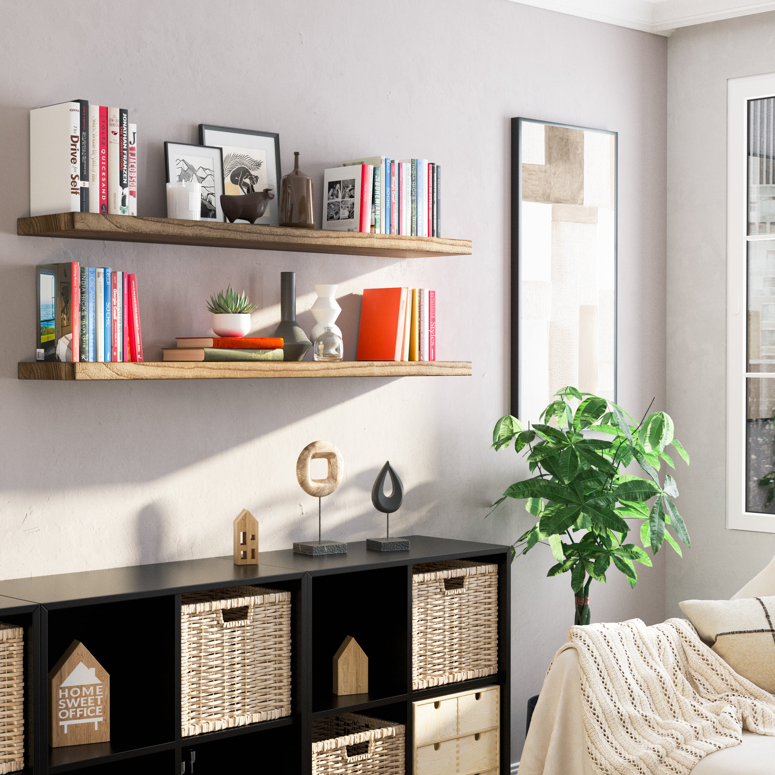 Two wooden floating shelves with invisible brackets are used to organize books and decorative items. Placed over a black cubby storage with woven baskets, the setup brings functional elegance to a cozy reading nook or small living space.