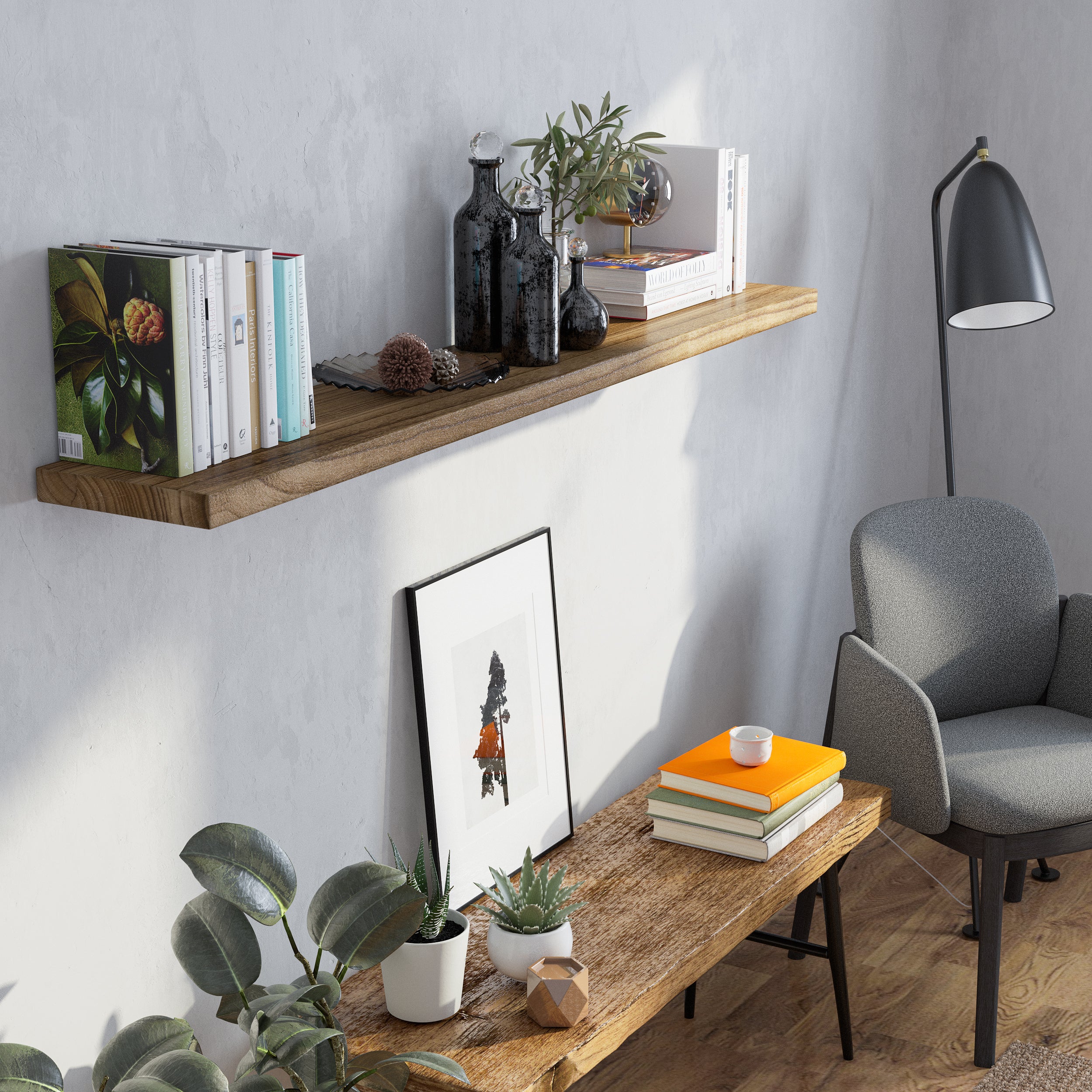 A single wood floating shelf for wall decor showcases a mix of books, glass bottles, and greenery against a soft gray wall. Styled with a minimalist touch, it creates a serene corner ideal for relaxing with a warm, earthy aesthetic.