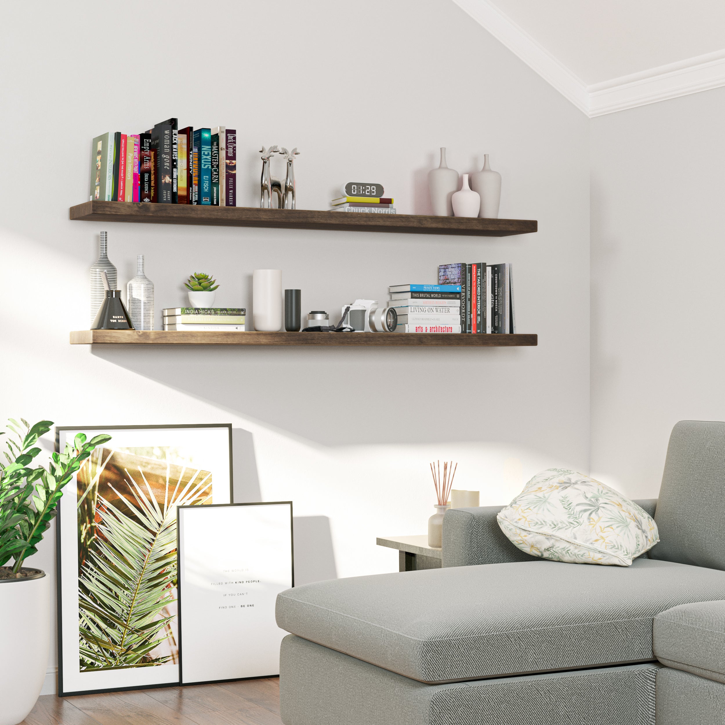 Two wood floating shelves with hidden brackets above a sofa corner, featuring books, decor items, and framed art. A cozy, modern reading nook with a relaxed ambiance.