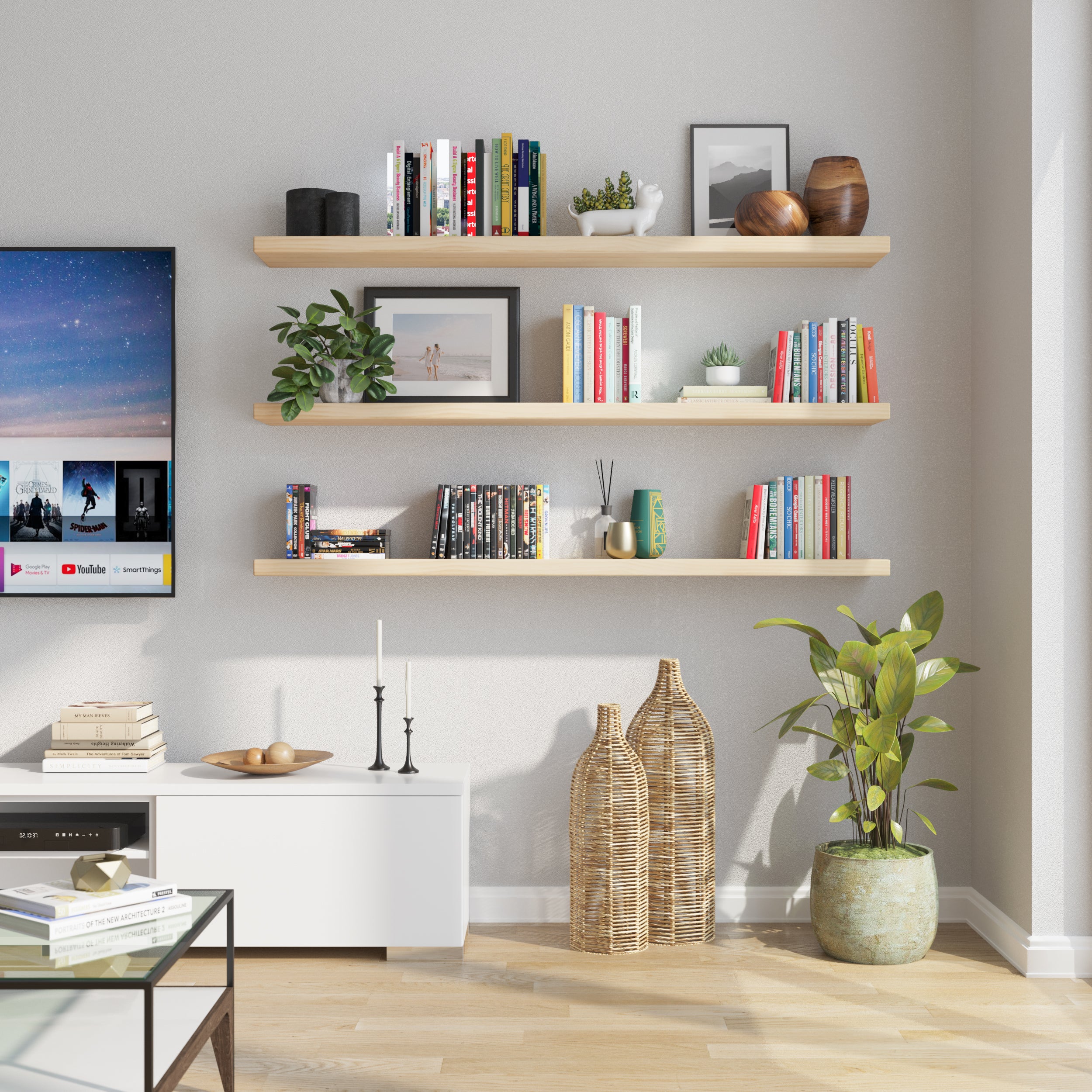 Three natural wood floating shelves neatly line a modern living room wall, holding books, plants, and decorative objects—perfect for showcasing personal style in a light-filled entertainment space.