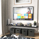 A 72 inch long floating wall shelf with invisible bracket in a rich ebony finish below a wall-mounted TV holds media items and decorative objects. Black cube storage and neutral tones complete the entertainment nook.
