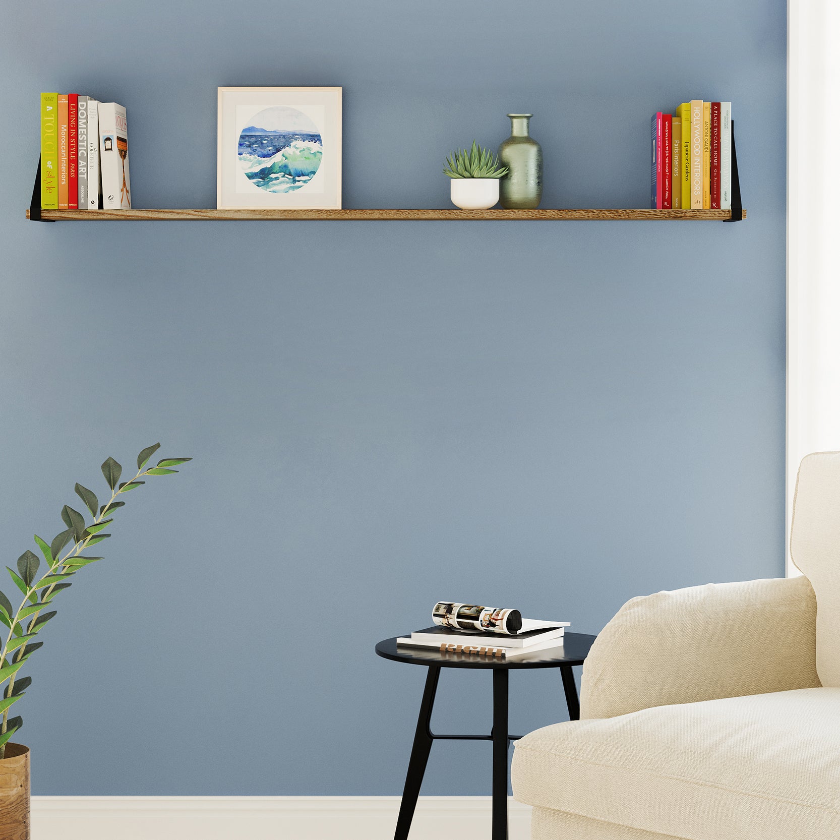 A simple reading corner setup with wall bookshelves above a table, displaying books and a small plant.