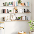Triple wood shelves on a soft cream wall, featuring books and minimal decor, blending functional storage with style in a home office or reading nook.