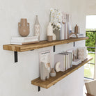 Long bookshelves styled with neutral decor pieces like books, vases, and orchid flowers. The soft beige wall and large window create a natural and airy look.