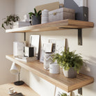 Home office with wall-mounted shelves supported by black metal brackets for stylish organization.