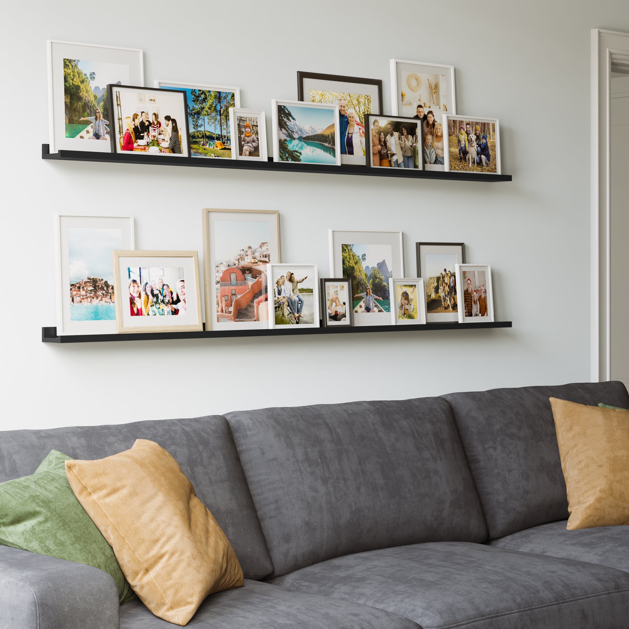 A cozy living space with a grey sofa and colorful pillows, and above it, black shelves filled with a mix of framed photos.