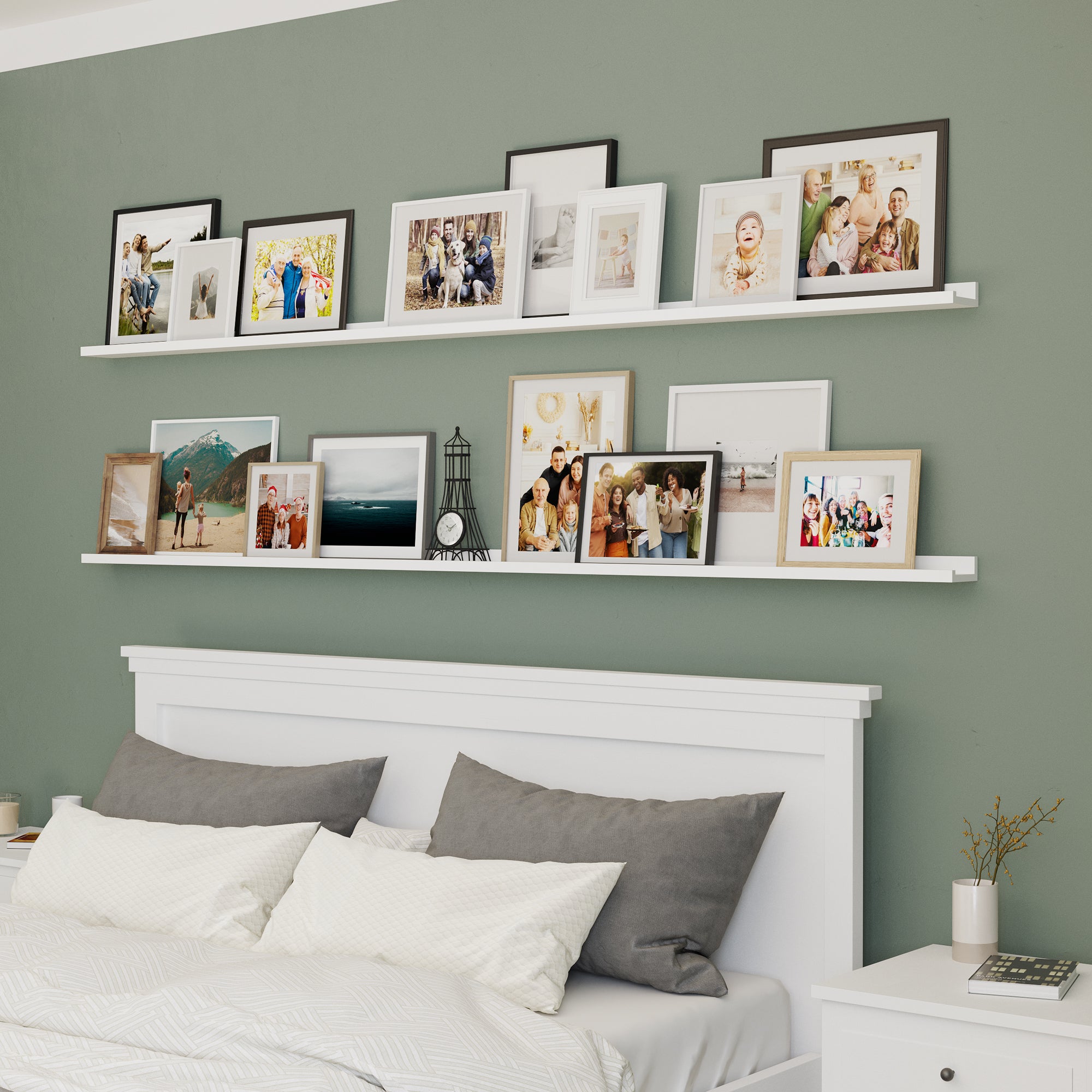 White shelves for bedroom with family picture frames above a bed with gray pillows.