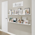 Shelves for wall decor with family photos and "this is us" sign against a textured wall..