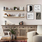 Two natural living room storage shelves above a wooden console. Decorated with books and ceramics, adding warmth and balance to a modern living room setup.