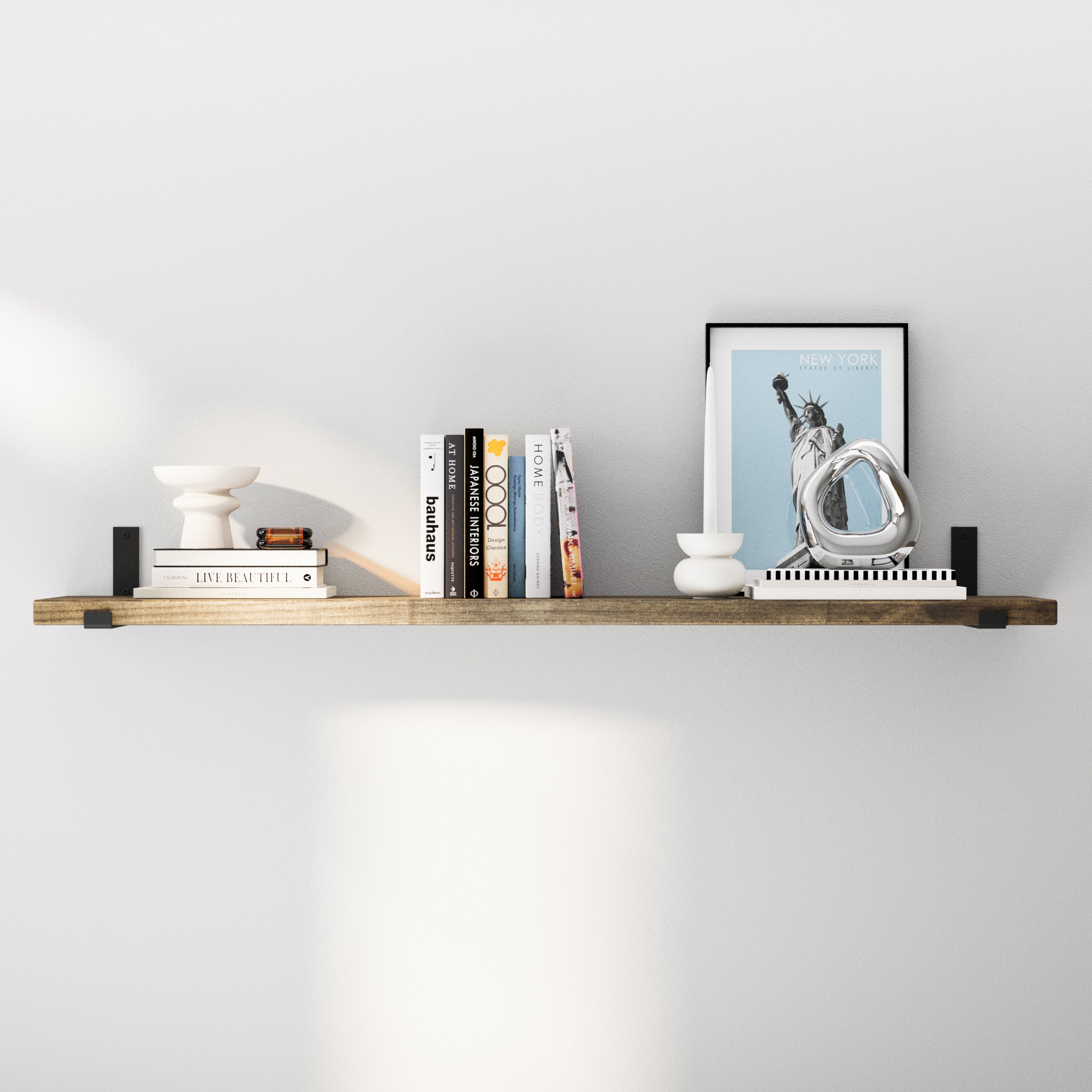 A 60 inch wall mounted shelf in a rich special walnut finish, styled with diverse decorative elements like books and small sculptures, underlining its adaptability for different room settings.