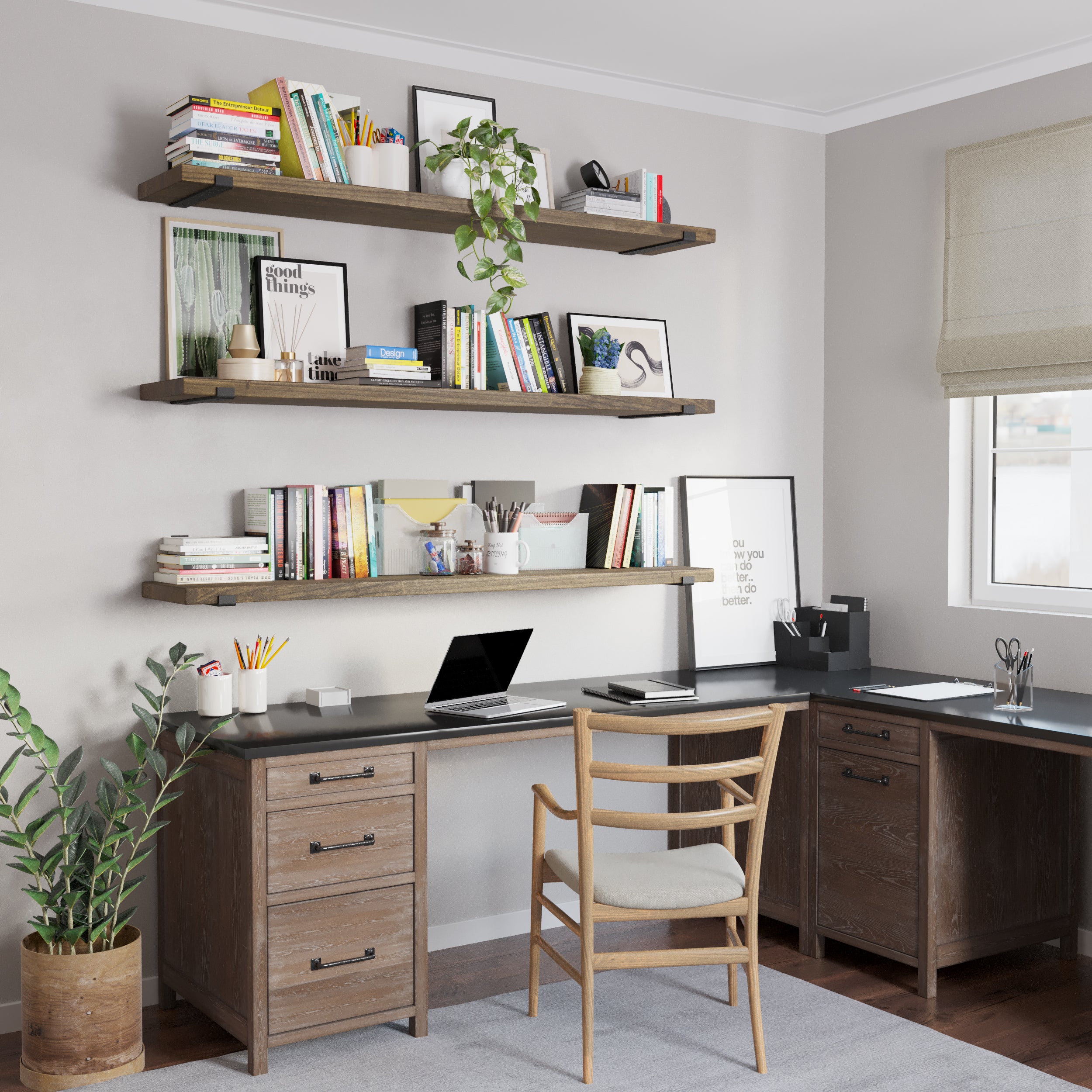 A functional home office setup featuring three wall mounted shelves in custom walnut finish adorned with books and decor. Below, an L-shaped desk with storage drawers, a wooden chair, and a potted plant create a balanced, productive environment.