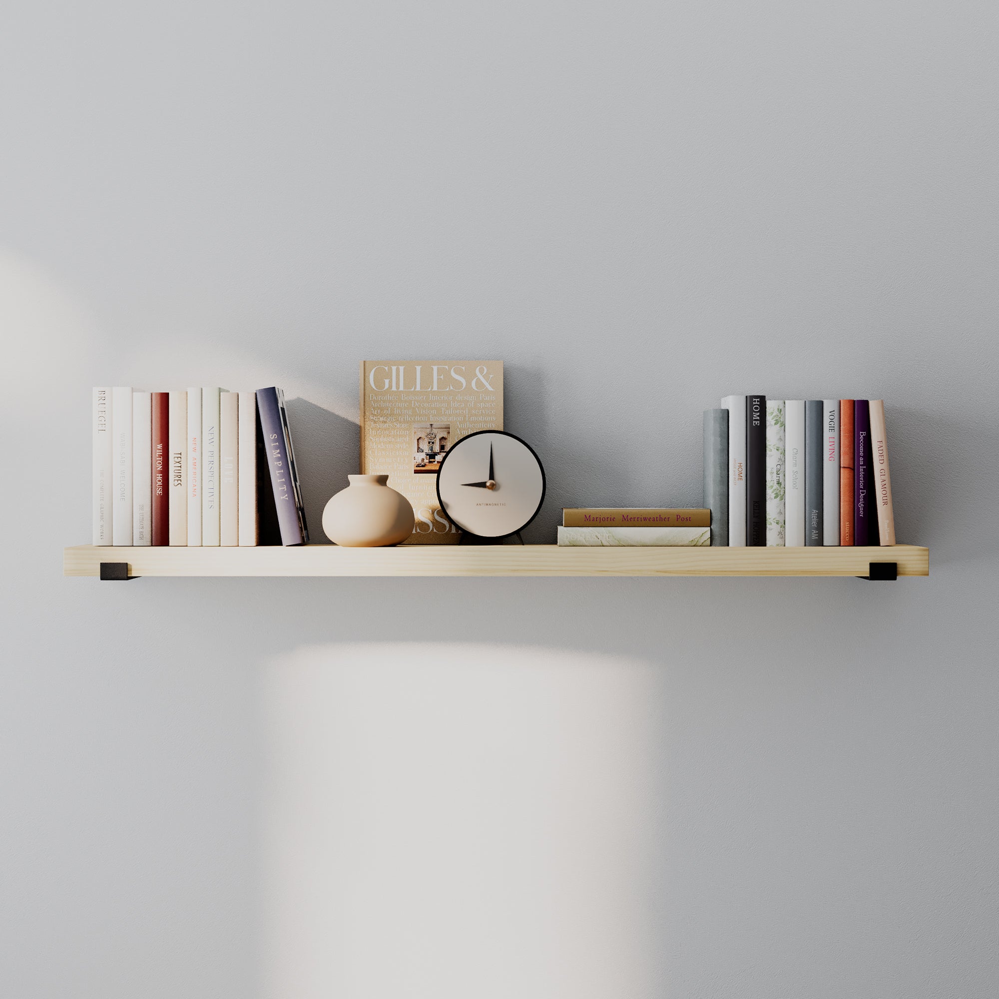 A ong wall mounted shelf styled with books, vase, and clock. Minimal, balanced composition emphasizes light wood tone, clean lines, and decorative versatility.