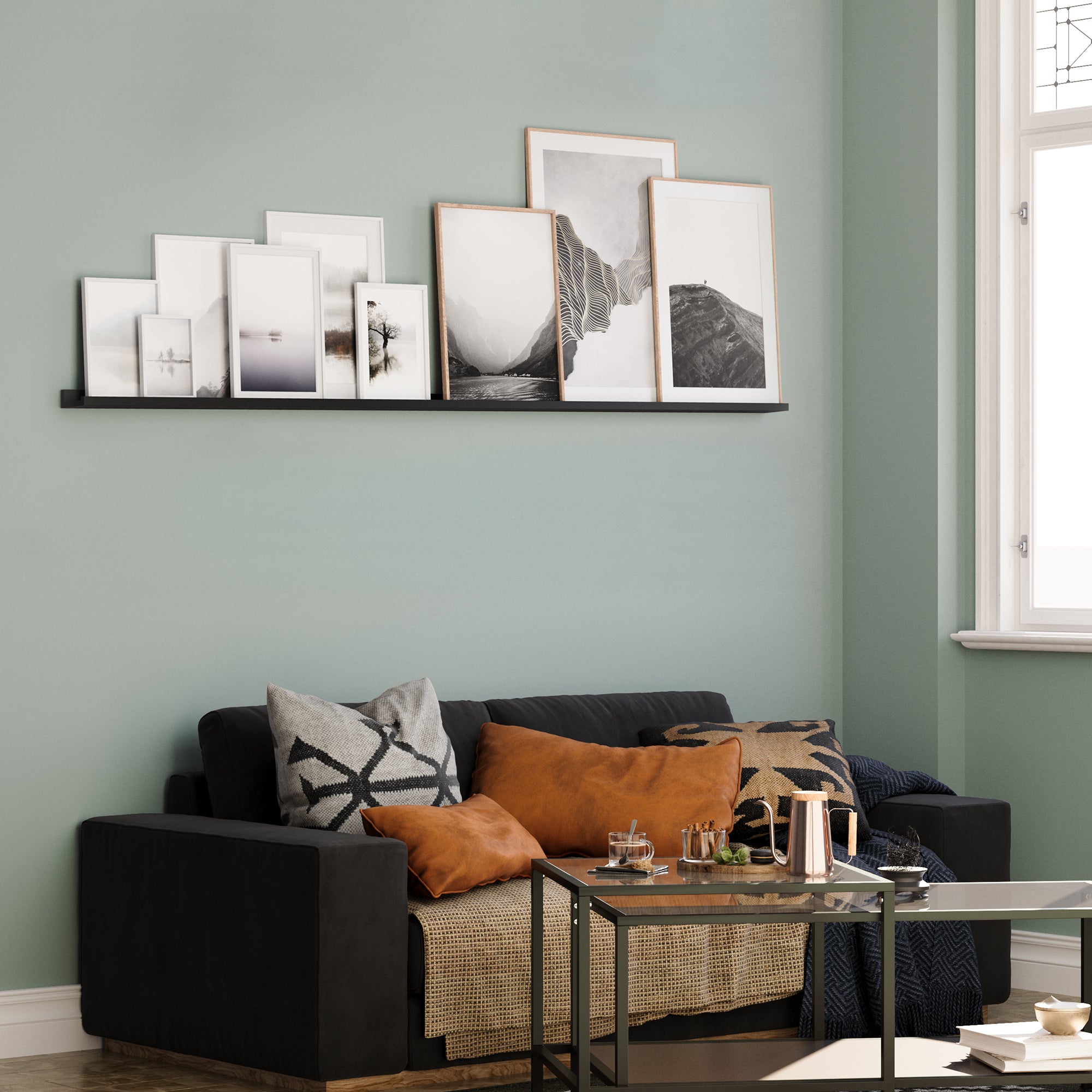 Black shelf displaying frames over a sofa in a living room.