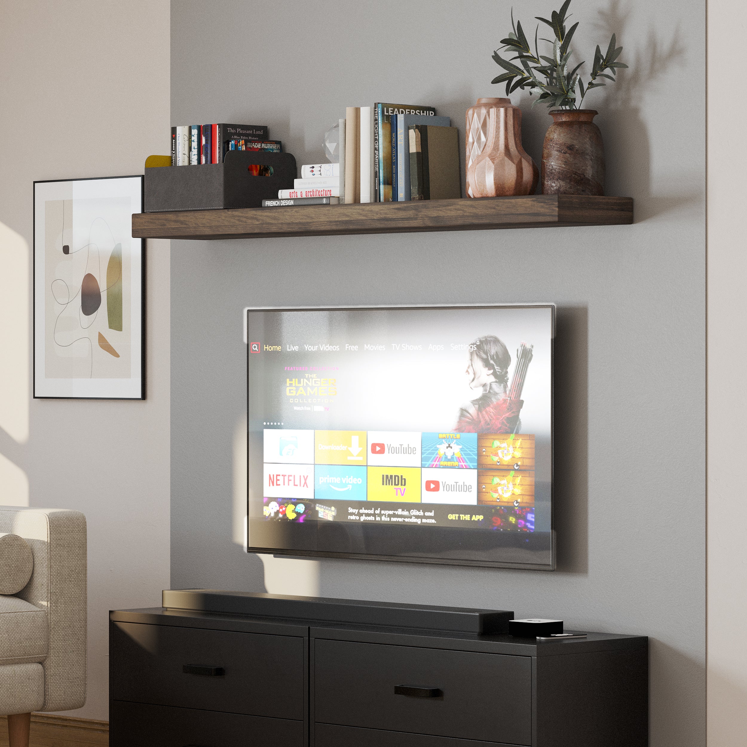 A media room shelf above the TV unit hosts small plants, neutral-toned books, and minimalist accents, creating a simple, elegant entertainment area backdrop.