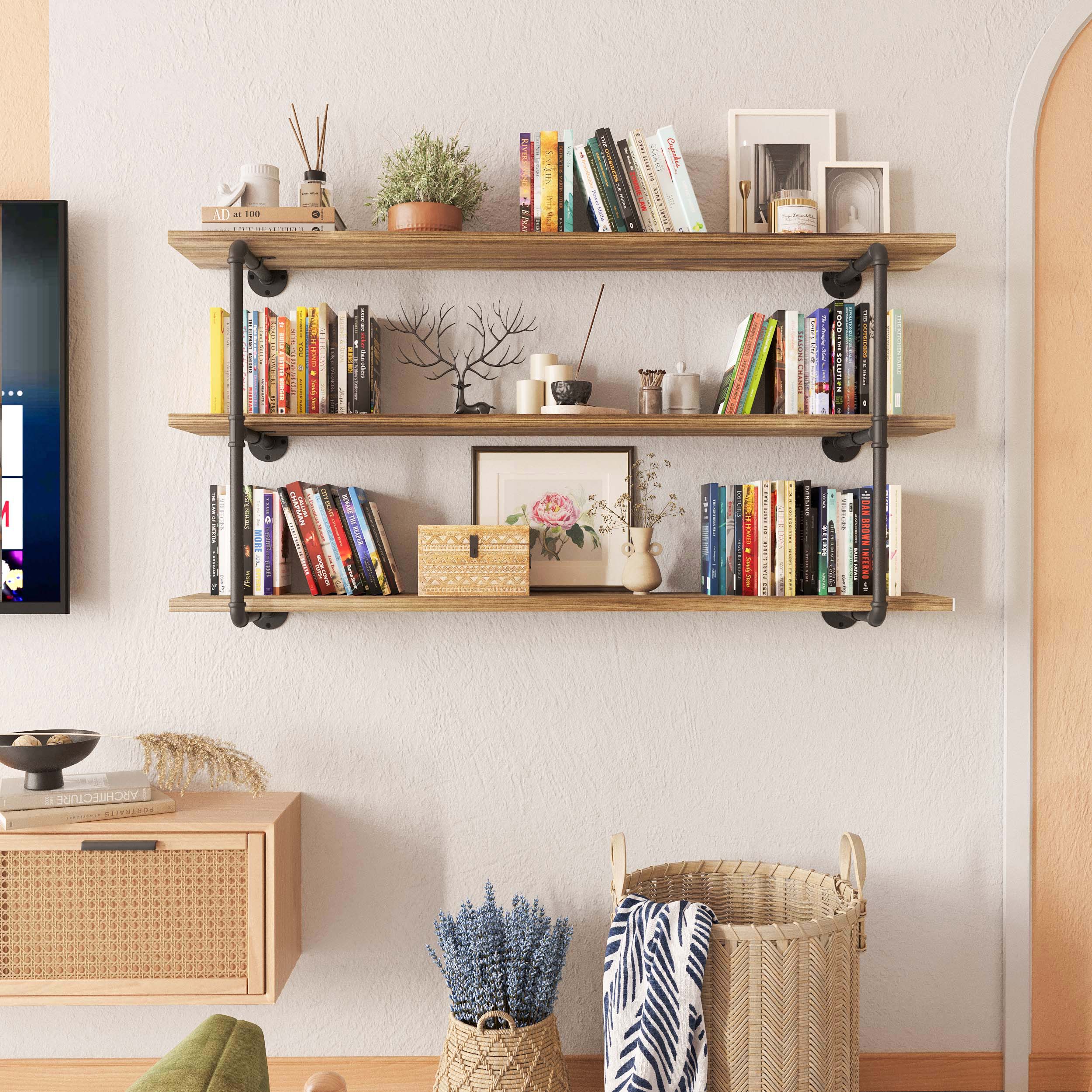 Cozy living room with PIPE 60'' Floating Pipe Shelves, 3 tiered and burnt color, displaying books and decorative items.