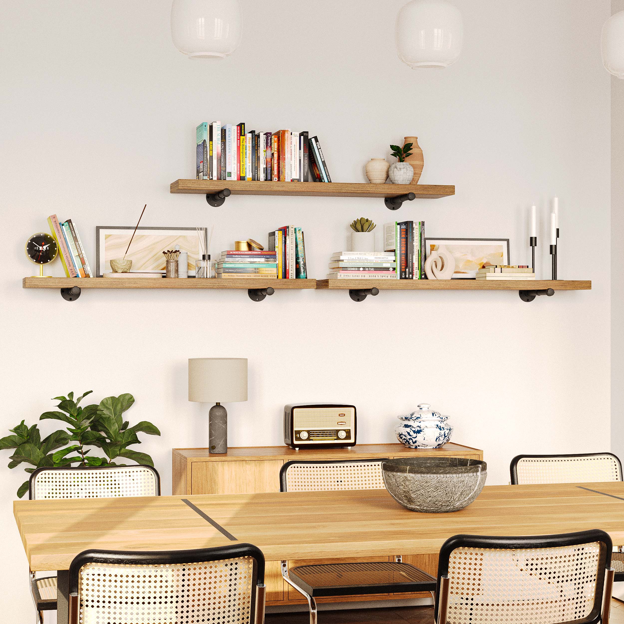 Three long shelves mounted in a dining space, showcasing books, candles, and elegant decor.