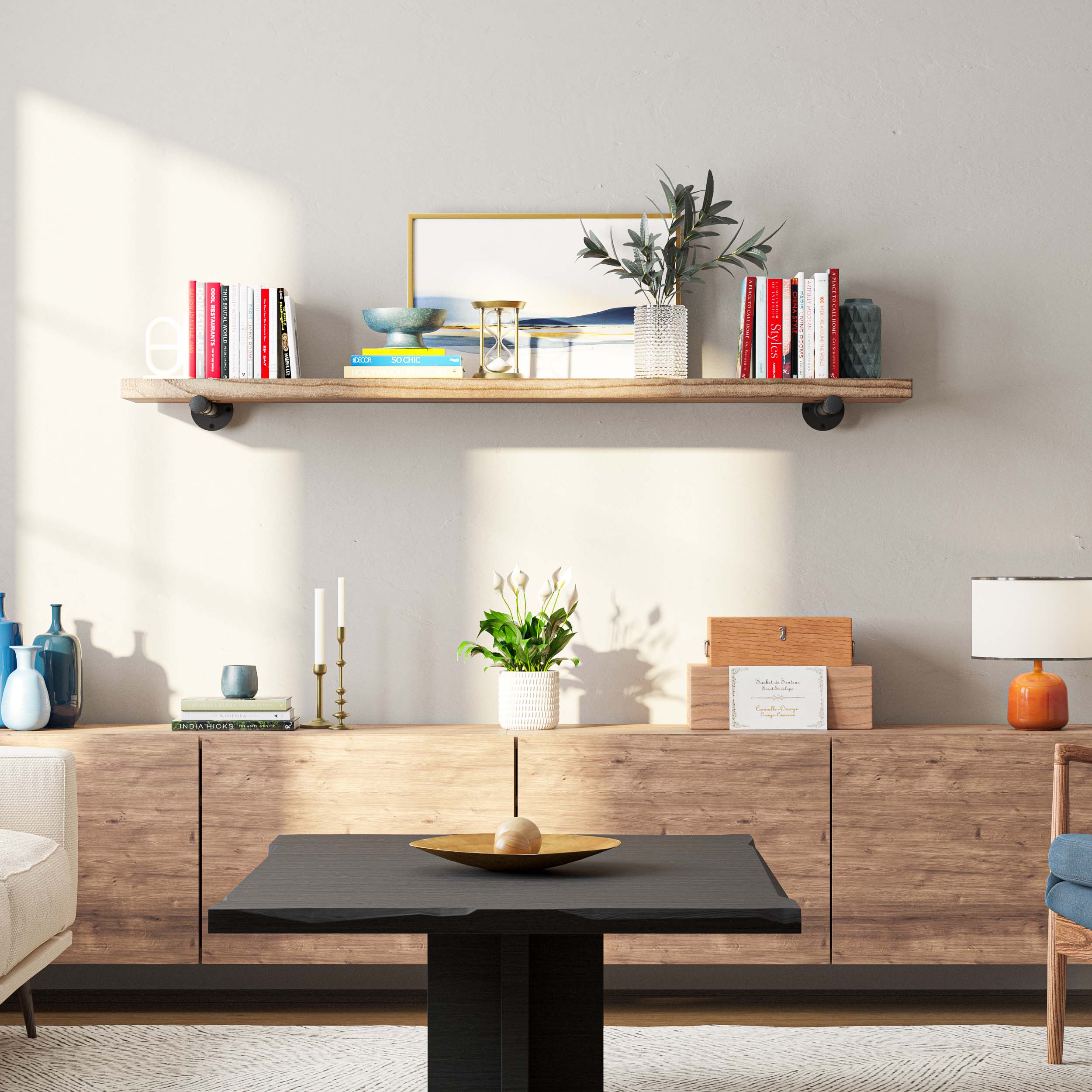 A long display shelf with books, vase, and artworks in a chic living room.