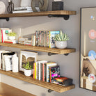 Three-tier shelving setup with books, plants, and decor, adding a stylish, functional element to the living space.