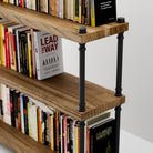 Farmhouse shelf with black pipe brackets holding books.