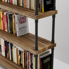 Wooden shelf with industrial pipe brackets with books on a white background