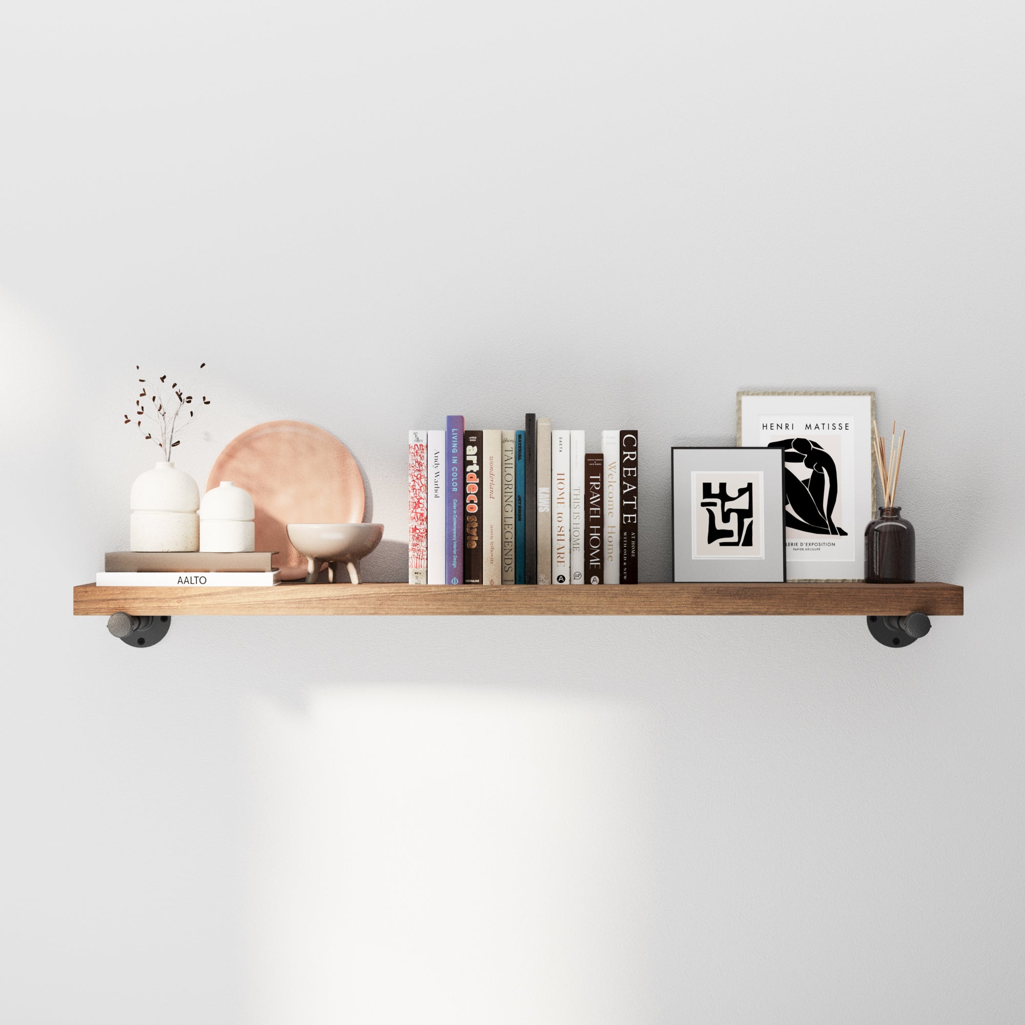 Industrial pipe shelf with decorative items against a white wall