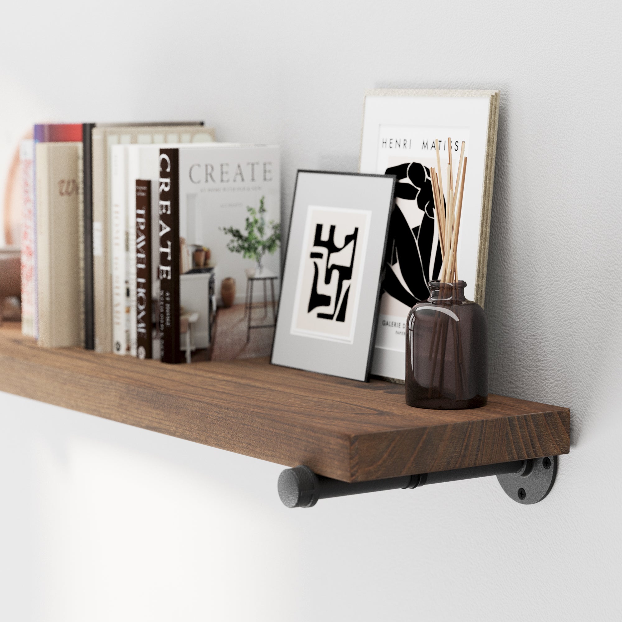 Office storage shelf with books, a picture frame, and a vase against a white wall.