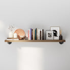 Pipe bracket shelf with decorative items against a white wall