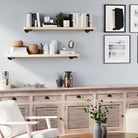 Modern interior with living room floating shelves, books, and decor against a light blue wall.
