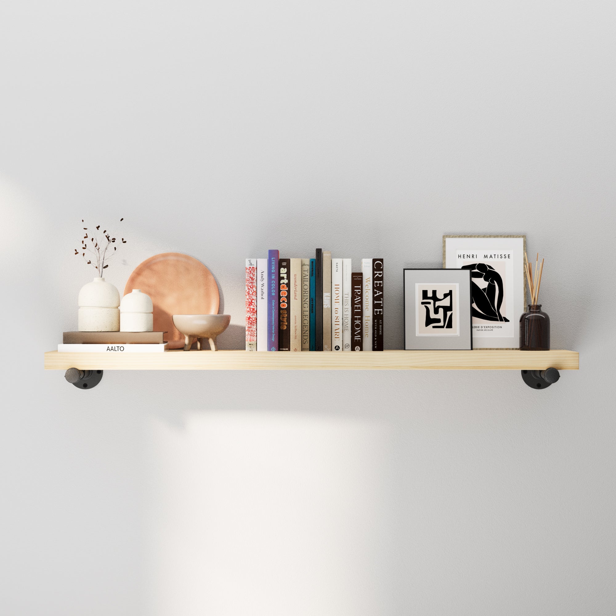 Real wood shelf with pipe brackets with decorative items against a light gray wall