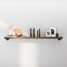 60" long floating pipe shelf styled with books, framed art, and décor accents. Rustic wood wall shelf with heavy-duty black pipe brackets adds modern farmhouse charm, ideal for living room wall décor, books, and decorative storage.