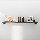 60" industrial pipe shelf in a rich ebony finish styled with books, framed art, and modern décor. Rustic wood wall shelf with heavy-duty black pipe brackets adds farmhouse charm, perfect for living room wall décor, books, and storage.