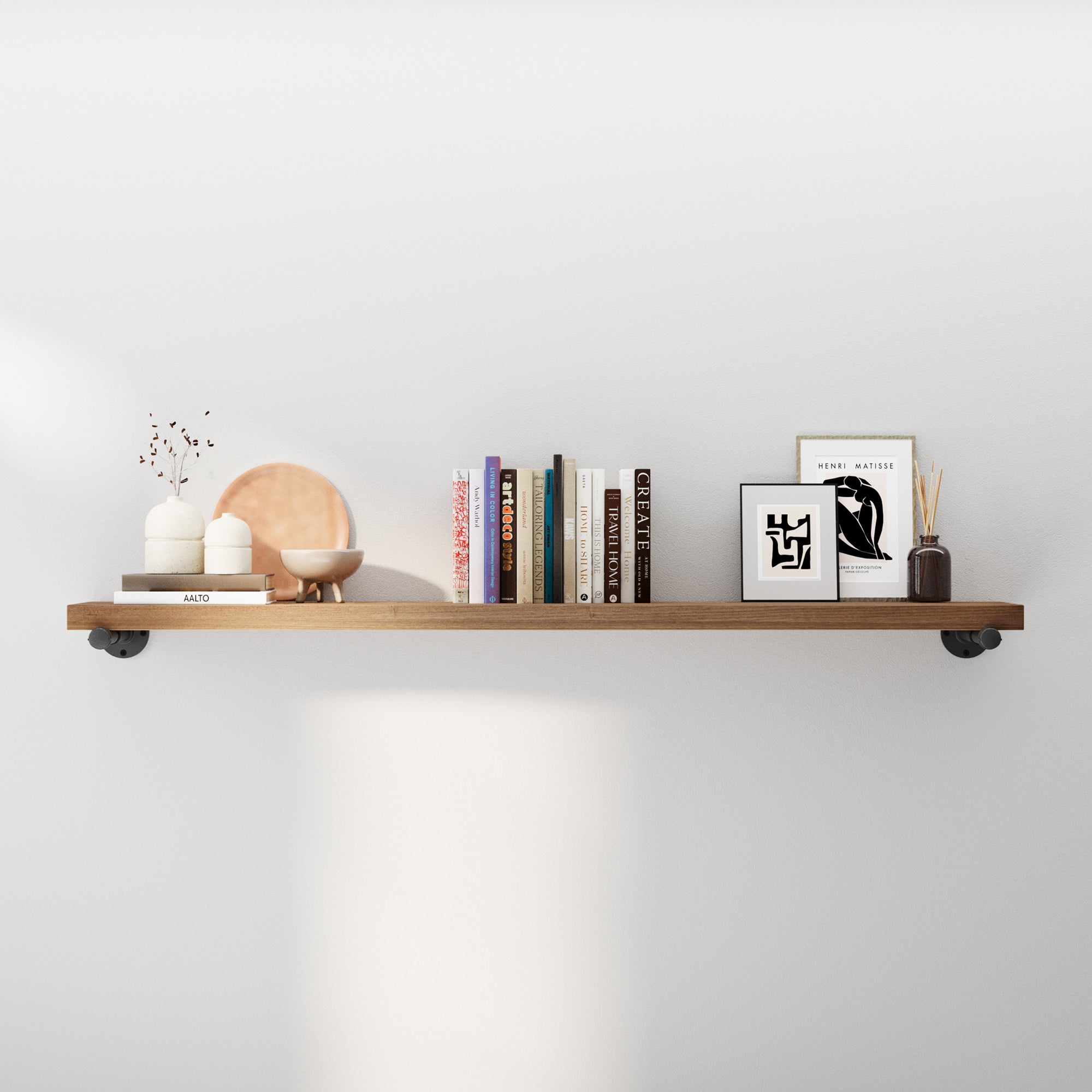 60 inch floating shelf in a rich special walnut finish styled with books and décor, featuring a rustic wood board and industrial pipe brackets. Ideal as a wall mounted bookshelf, farmhouse shelf, living room décor, or extra long storage shelf.