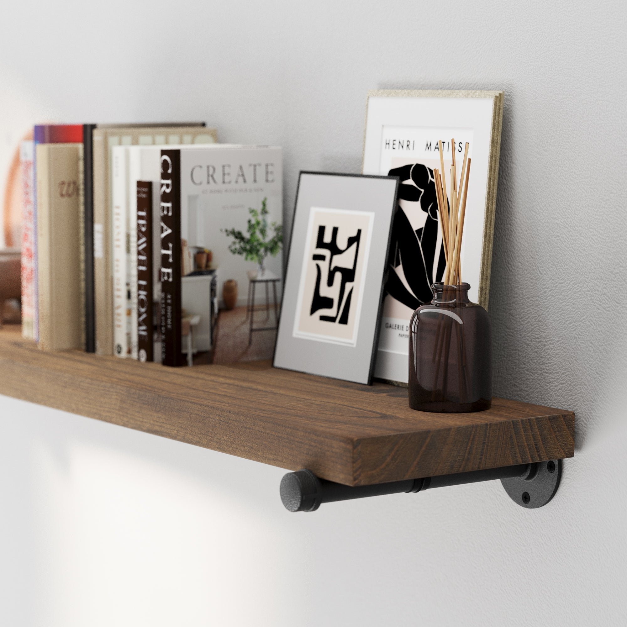 A 60” pipe wall shelf highlighting natural wood grain, sturdy black metal brackets, and decorative styling. A rustic floating bookshelf for entryway décor, office shelves, or modern farmhouse storage.