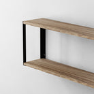 Double-layer wooden shelf supported by black rectangular wall brackets mounted on a wall.
