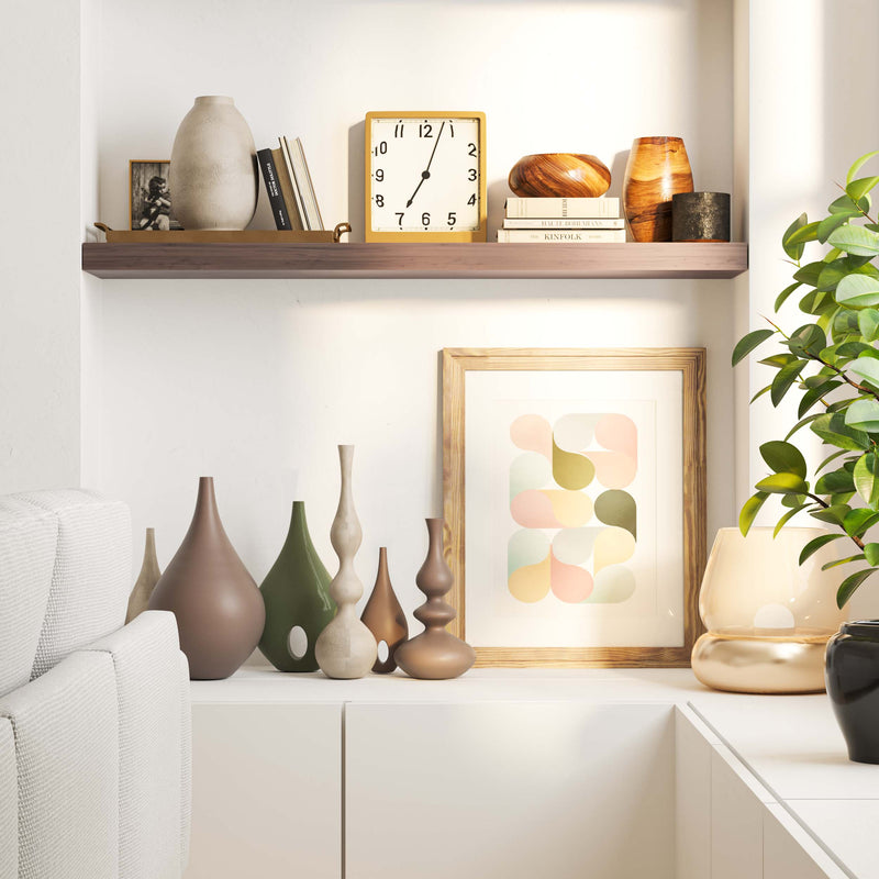 A living room shelf adorned with a diverse collection of vases, a framed print, and a classic clock, creating a stylish and serene display in a modern home.