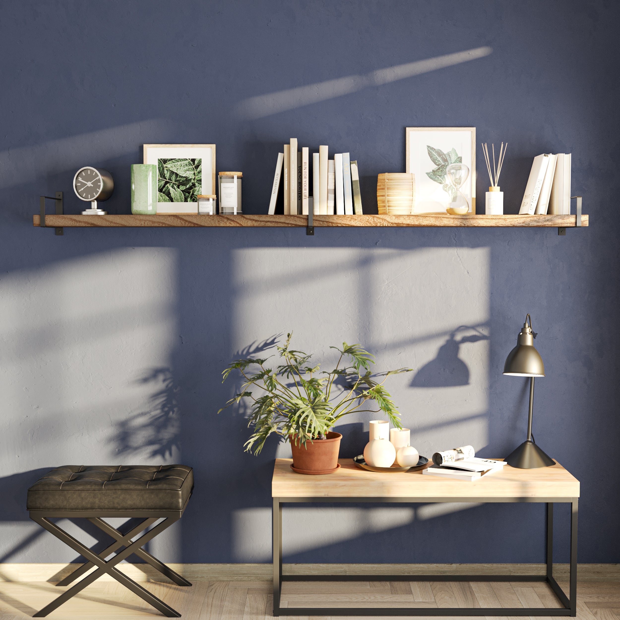 A single long shelf on a navy wall adds striking contrast and modern appeal. Styled with books, frames, and candles, it creates a functional focal point above a minimalist wooden console.