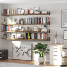 Four wall-mounted wall book shelves display books, planners, and decorative items like clocks and vases. A world map leans beneath the lowest shelf, completing this productive and inspiring office setup.