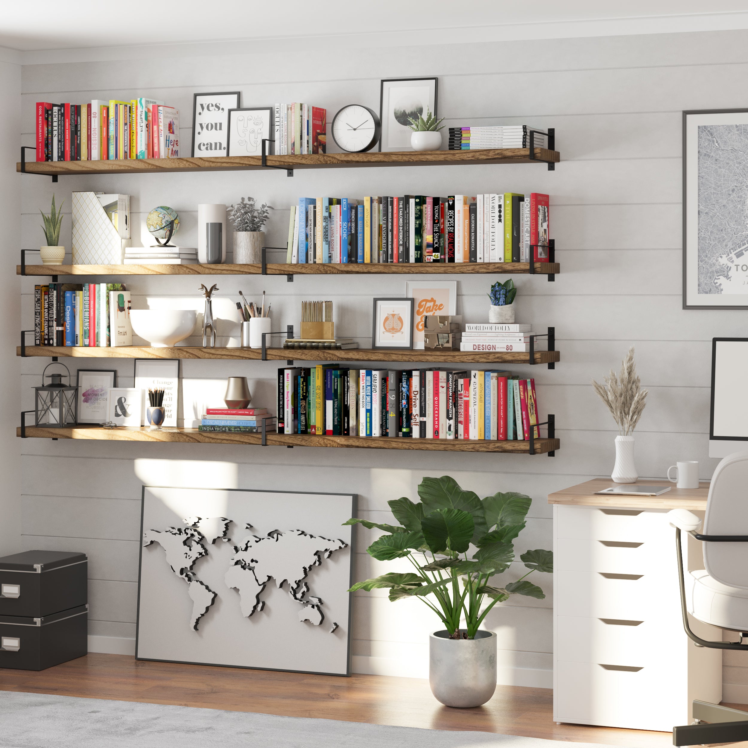Four wall-mounted wall book shelves display books, planners, and decorative items like clocks and vases. A world map leans beneath the lowest shelf, completing this productive and inspiring office setup.