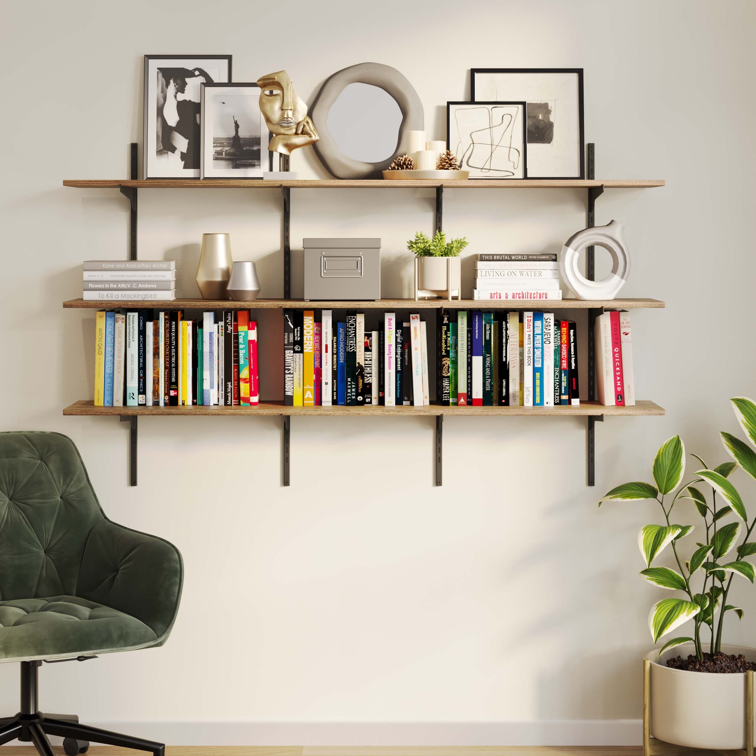 Hanging book shelves for wall filled with colorful books, artistic sculptures, and diverse frames, complemented by a chic green armchair and a vibrant plant to the right.