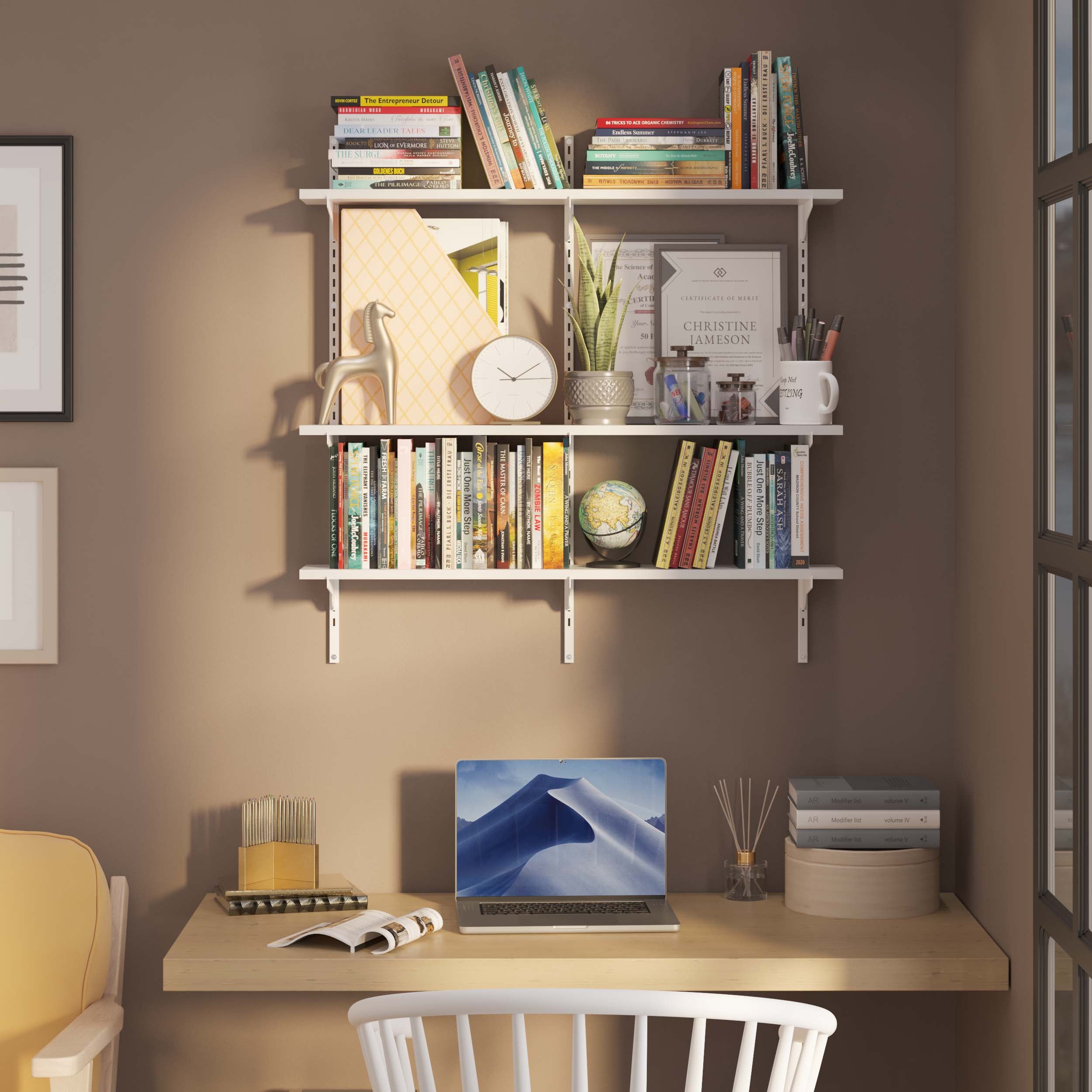 Workspace with wall shelves for office above a desk holding books and office supplies.