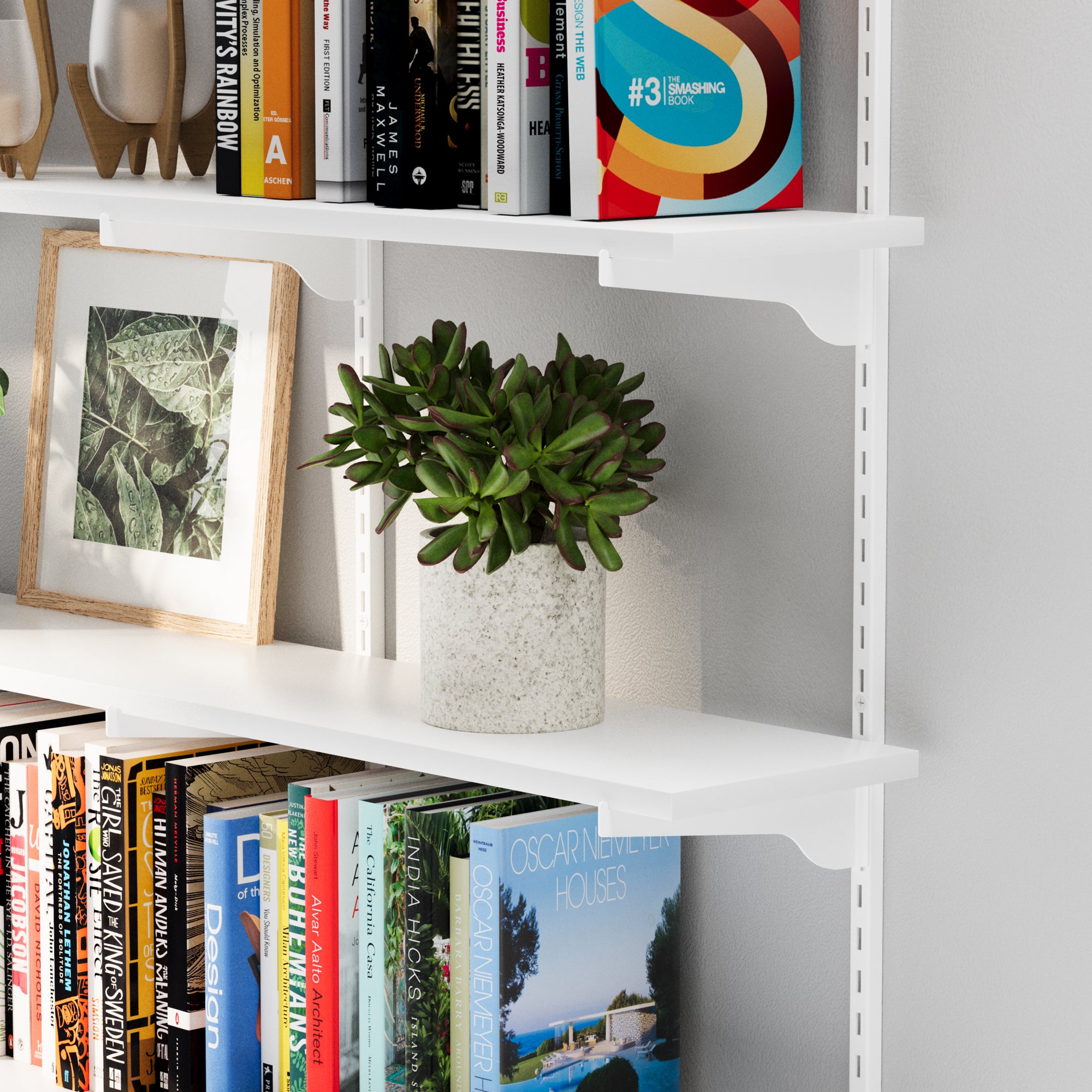 The wall book shelf corner showing its sturdy white metal bracket and neatly placed ceramic bowl and decor accents.