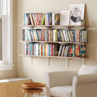 60 inch long farmhouse  shelf used as a home library in a cozy reading nook. Demonstrates how the 60” wall bookshelf can accommodate a large book collection with style and efficiency.