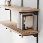 Floating book shelves for wall decor with books and decorative items against a white wall