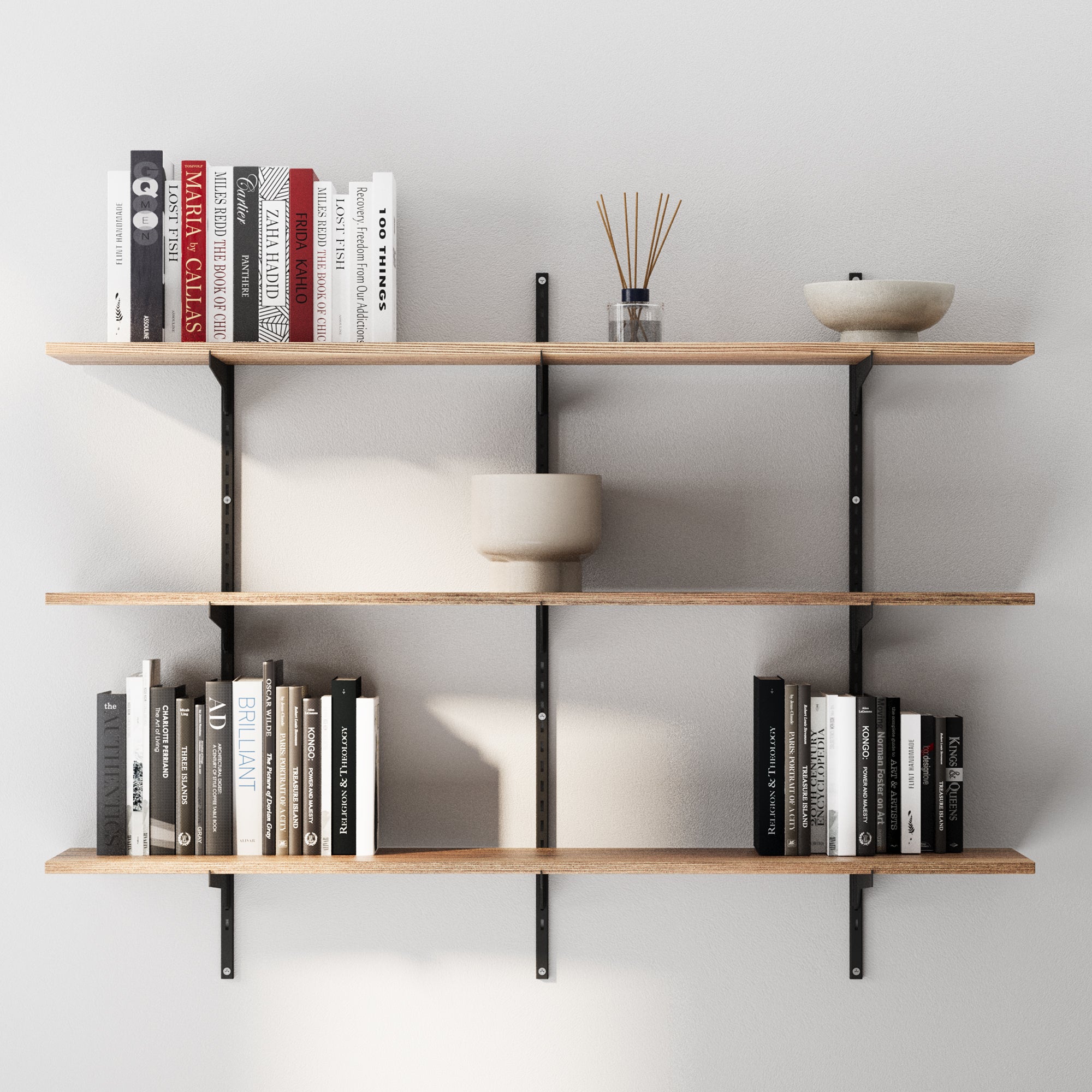 3 tiered floating wall bookshelf with black adjustable brackets holding books and decorative items against a plain wall