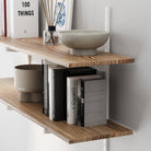 Wood shelving unit for home organization with books and decorative items against a neutral wall
