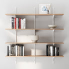 4 tiered boho shelves for wall decor with books and decorative items against a gray wall