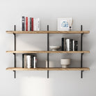 3 tier wall mounted farmhouse shelf with books and decor items against a white wall