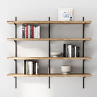 4 tier wall mounted decorative shelf with books and decor items against a white wall