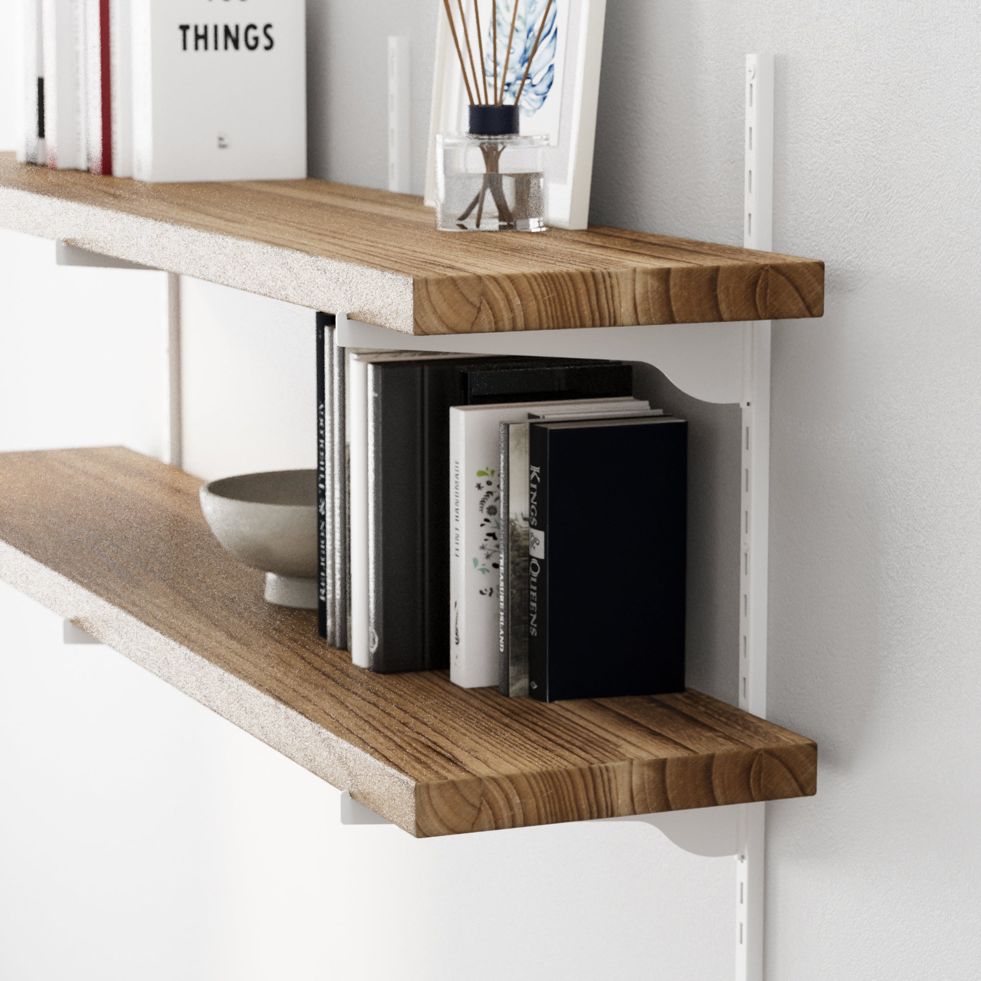 Floating bookshelf in rich burnt finish with books and decor items against a white wall
